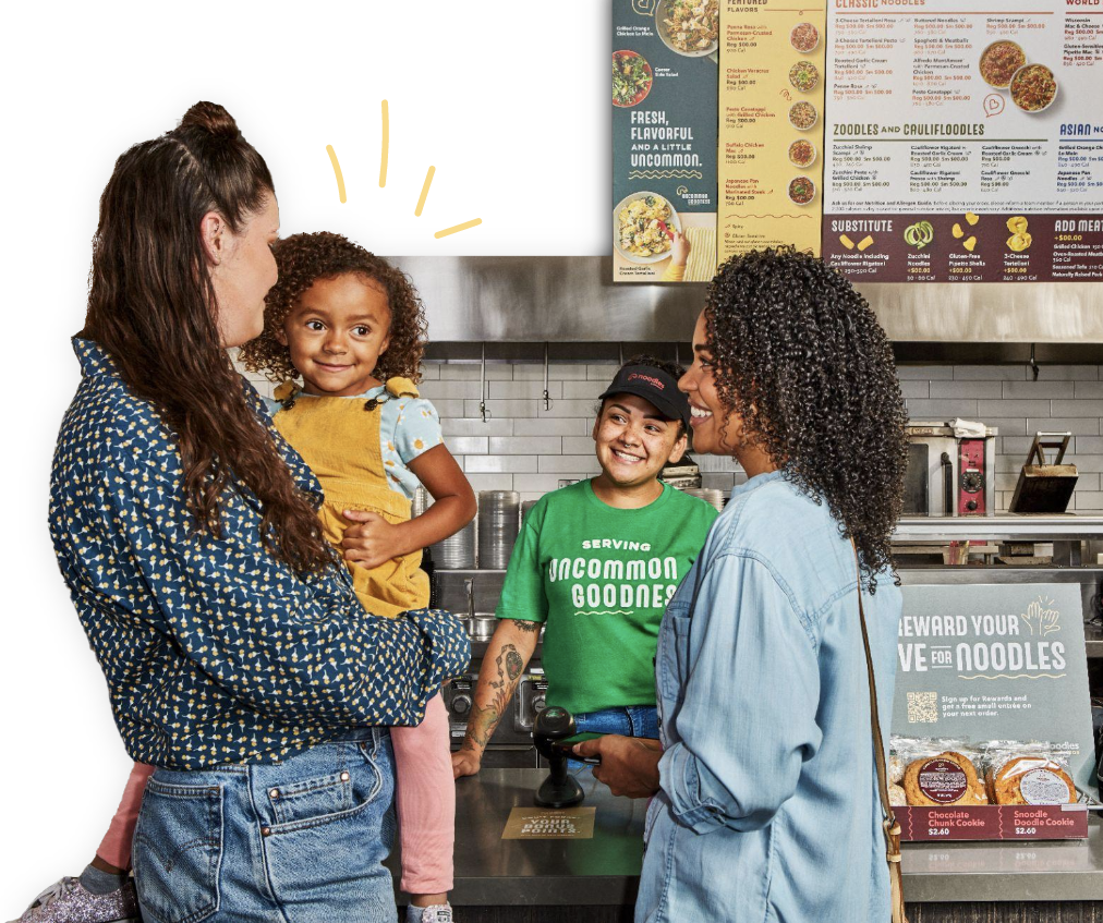 A happy family near a Noodles counter